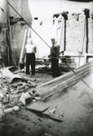 863418 Afbeelding van twee mannen die bezig zijn met de sloop van het pand Lange Koestraat 5 (voormalig café Van Wegen) ...